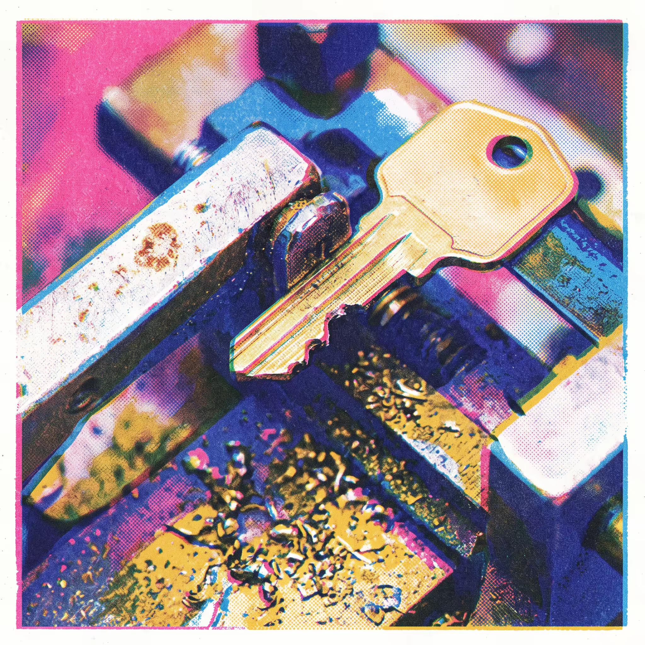 A blank brass key clamped in a small vise mid-engraving, with metal shavings scattered across the worktable
